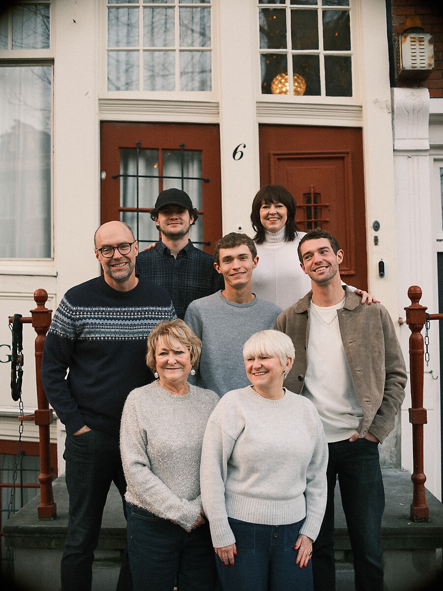 Seven members of one family gathered on the red front steps of an Amsterdam house on a winter afternoon