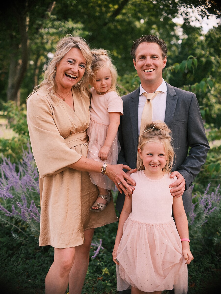 Family of four laughing together among the lavender of an Amsterdam garden in late summer