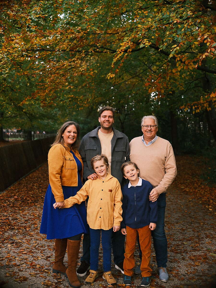 Three generations on a leaf-covered path, an autumn family photoshoot in Amsterdam