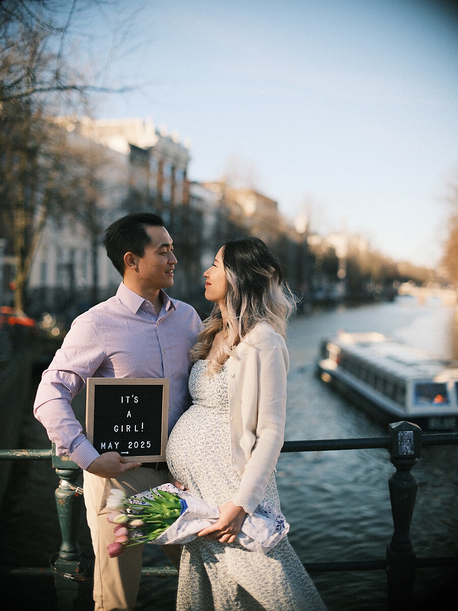 An It's a Girl letterboard and a bunch of tulips on an Amsterdam canal bridge, announcing a new family member