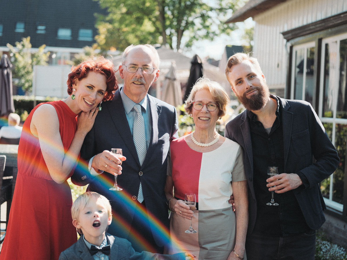 Family portrait on the terrace in Rotterdam, the golden anniversary couple with a woman in red, a bearded man and a boy in a bow tie