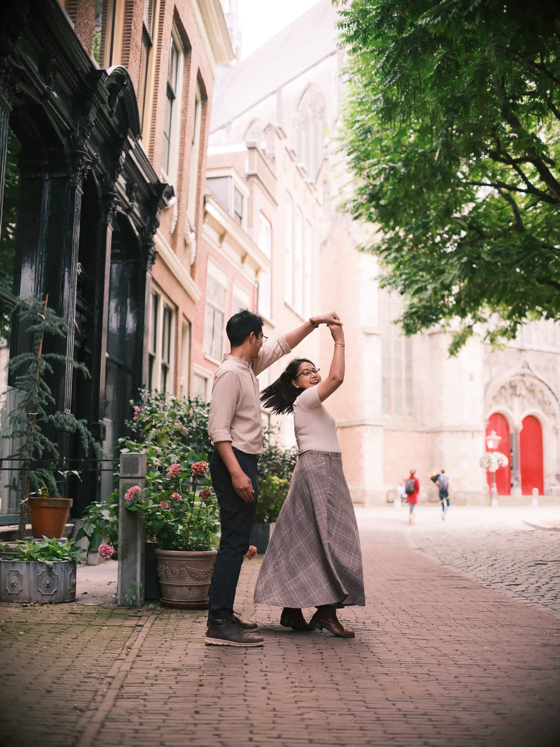 She laughs as he spins her by the hand, her long skirt swinging, two bright red church doors far behind them in Leiden
