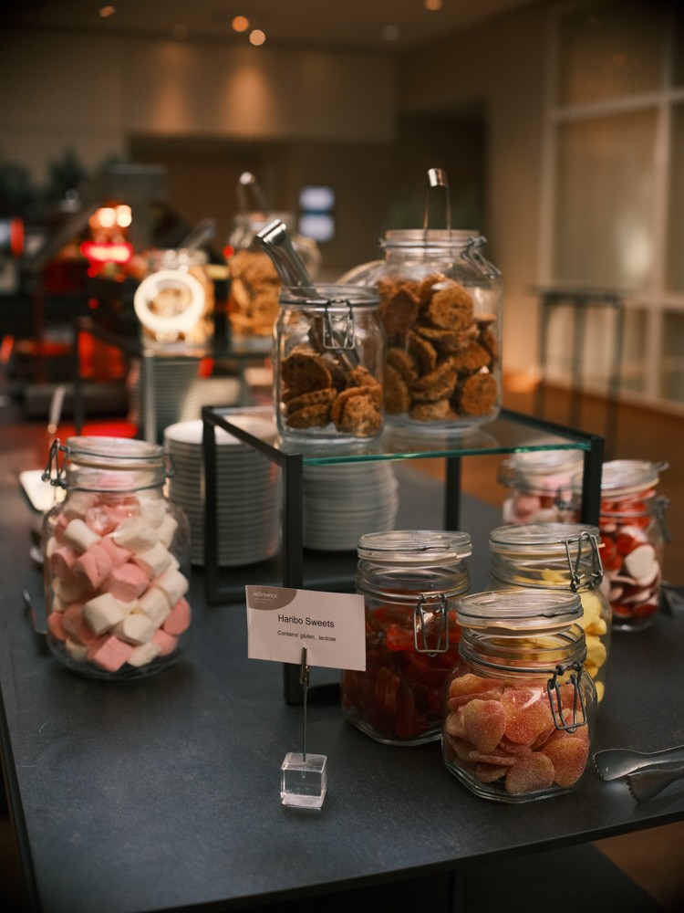 Glazen potten met koekjes, spekjes en snoepjes op een snoeptafel tussen de sessies van de congresdag door