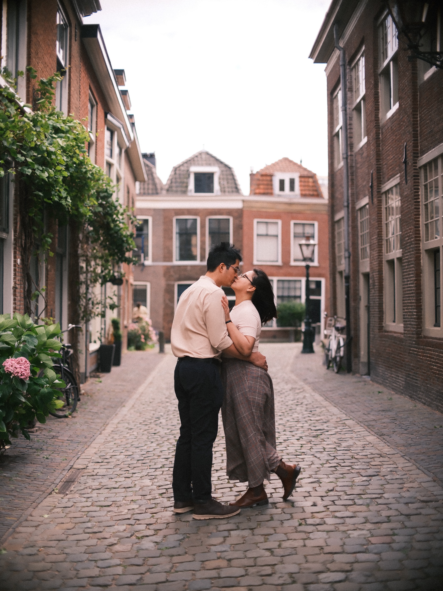 On tiptoe in a narrow brick street, she kisses him and lifts one foot off the cobbles, gabled houses closing the view
